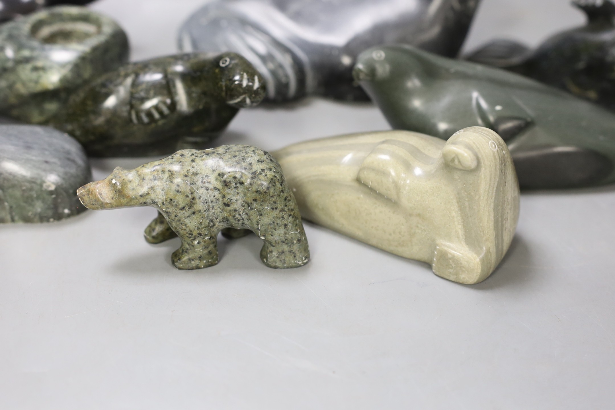 A collection of carved Canadian Inuit seal figures, largest 18 cm long (9)